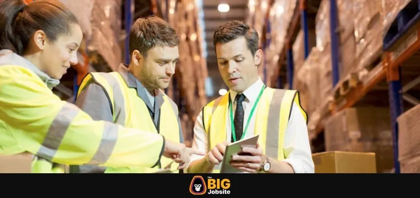 Business man and workers talking in warehouse